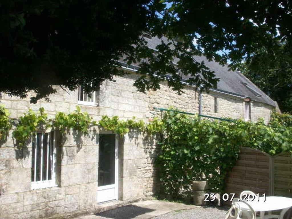 a brick building with a door and some vines at Gîte des Oiseaux in Bieuzy-les Eaux