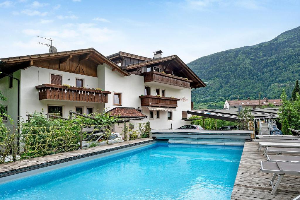 a villa with a swimming pool in front of a house at Residence Sonngart in Lagundo