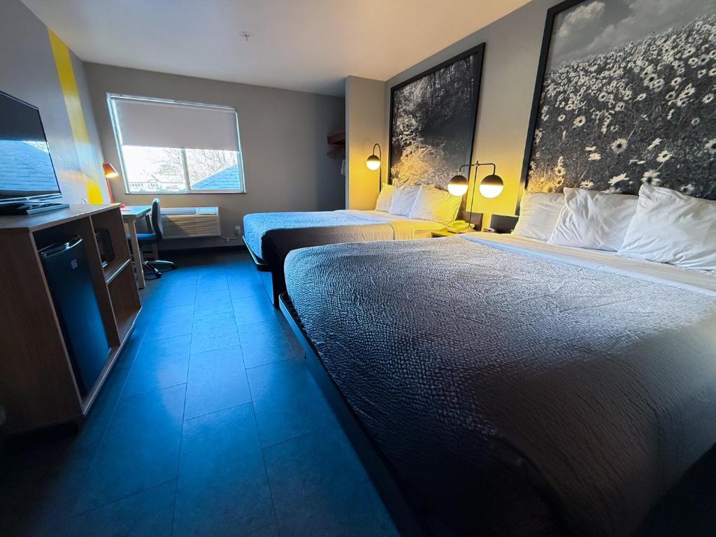 a hotel room with two beds and a flat screen tv at Super 8 by Wyndham Windsor in Windsor