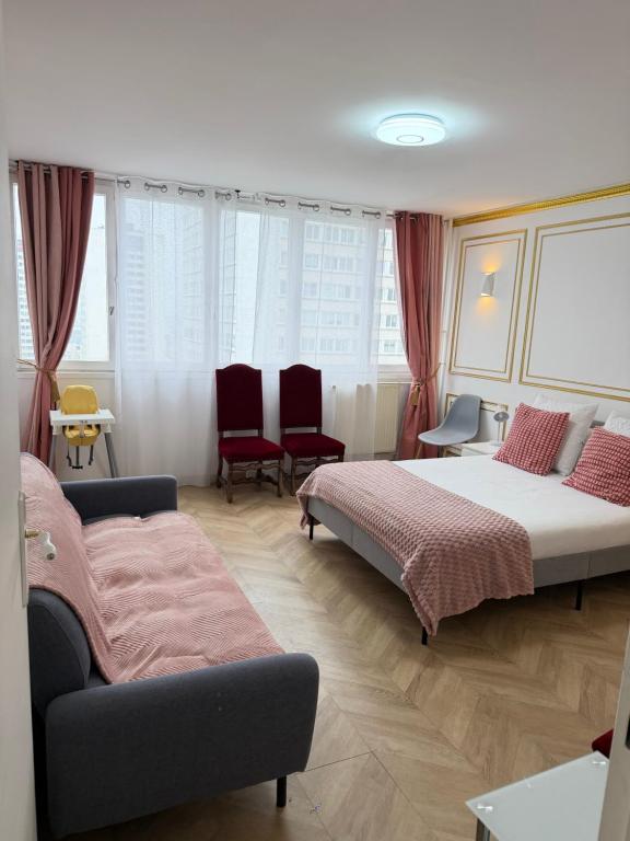 a bedroom with two beds and a couch and chairs at SCI IMMO PARIS PORTE DE CHOISY in Paris