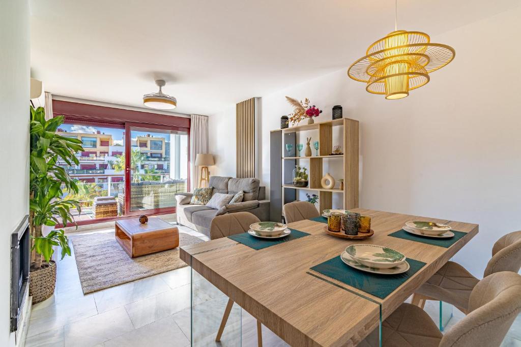 a living room with a wooden table and a dining room at Parque Botanico Resort Country club in Estepona