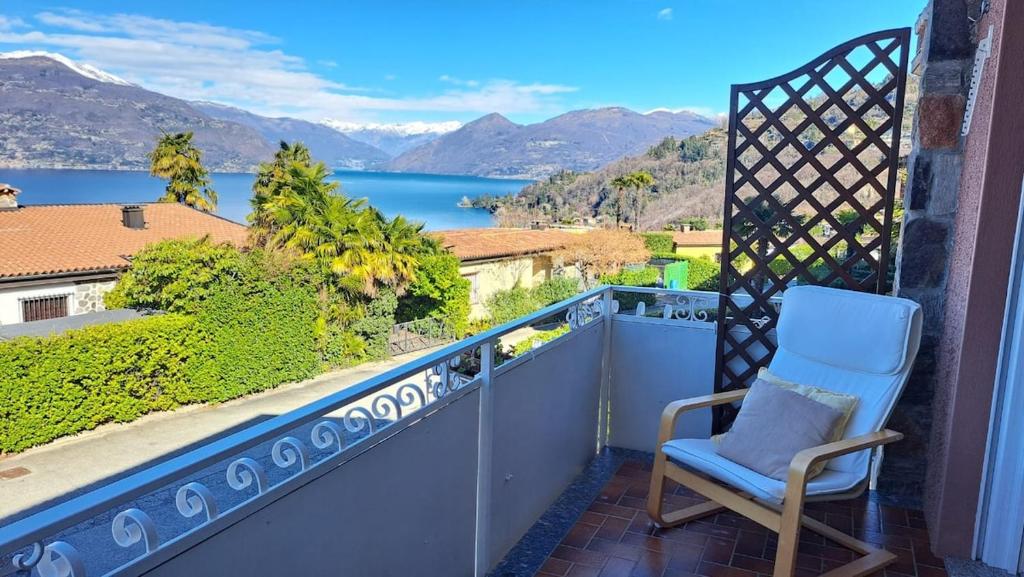 a chair on a balcony with a view of the water at La terrazza sul Lago Maggiore in Brezzo