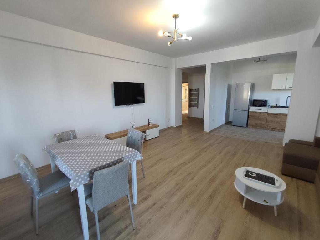 a living room with a table and chairs and a kitchen at Voievozilor Residence in Constanţa