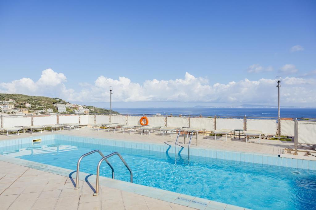 a swimming pool with the ocean in the background at Grand Hotel Cesare Augusto in Sorrento