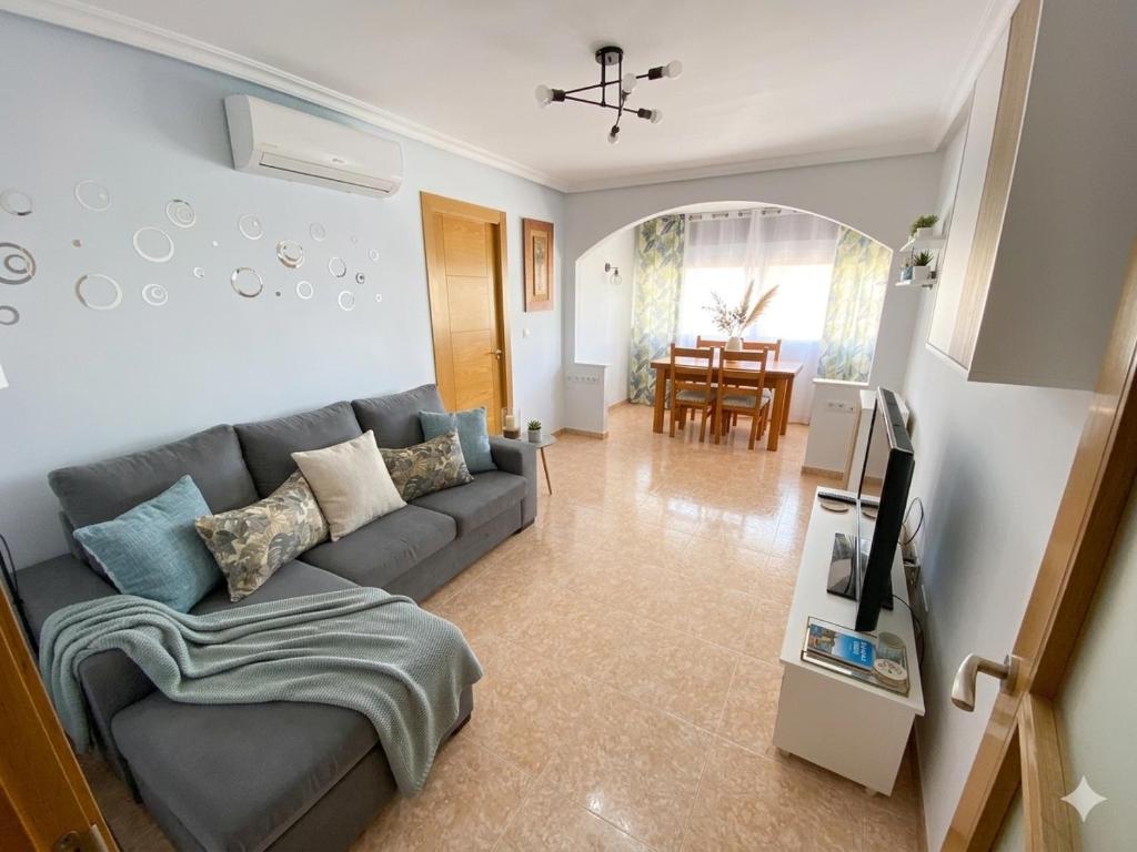 a living room with a couch and a dining room at Apartamento EL SOL DEL ZAPILLO in Almería