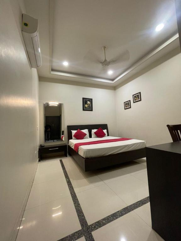 a bedroom with a bed with red pillows on it at Hotel Oval Hut in Jalandhar