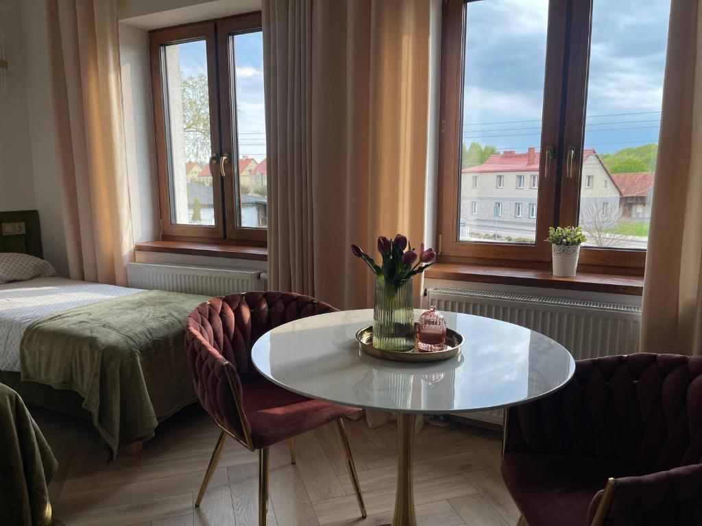 a room with a table and two chairs and a bed at Hotel & Restauracja Kormoran in Orzysz