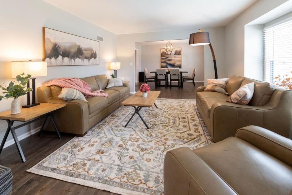 a living room with two couches and a dining room at Spacious 4 BR 3 BA with Fenced Yard in Shawnee