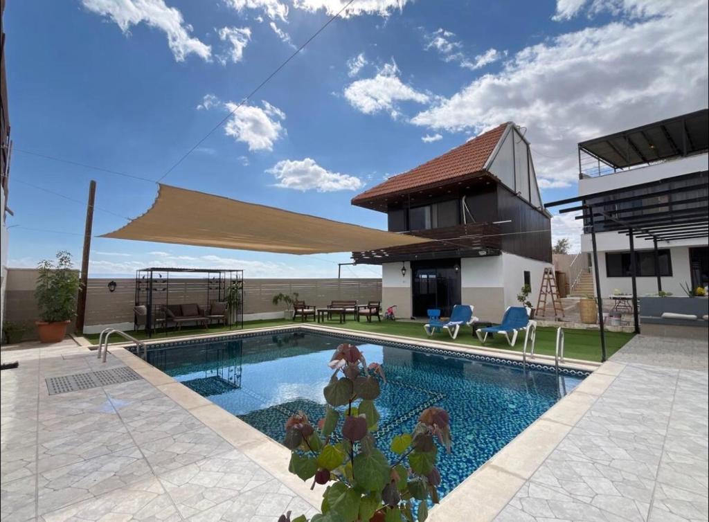 ein Schwimmbecken mit einem Sonnensegel darüber in der Unterkunft panorama villa boutique HT in Jericho