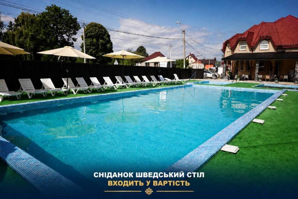 a large swimming pool with lounge chairs at Aqua Hotel in Solotvyno