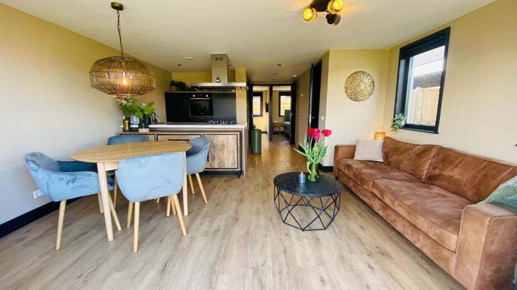 a living room with a couch and a table at Family holiday home by beach and forest in Dirkshorn