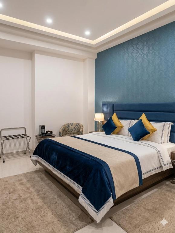 a bedroom with a large bed with a blue wall at Hotel Banana Tree & Banquets 5 Min From Anand Vihar Bus Terminal and Vaishali Metro Station in Ghaziabad