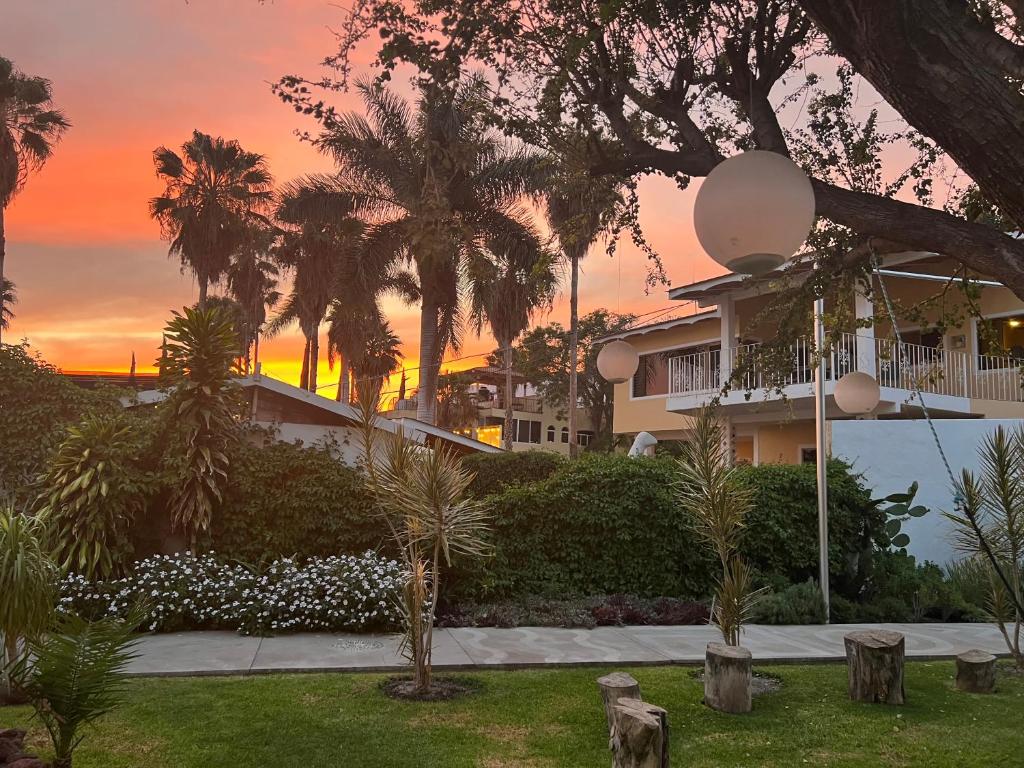 a house with palm trees in front of a sunset at Cosalá Grand in San Juan Cosalá