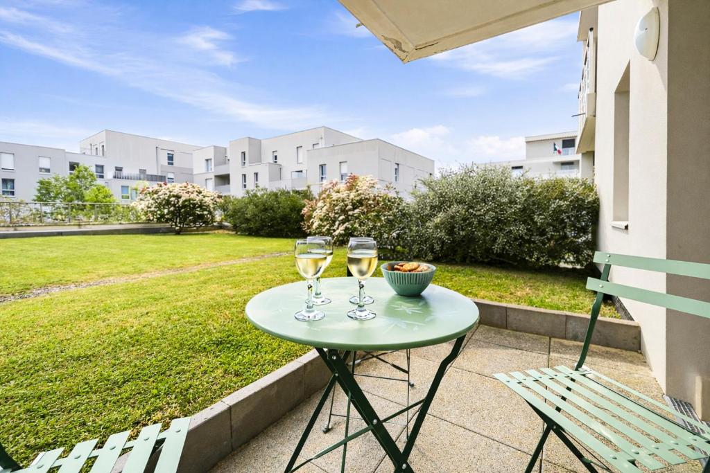 two glasses of wine sitting on a table on a patio at T2 moderne avec terrasse, central et calme in Saint-Herblain