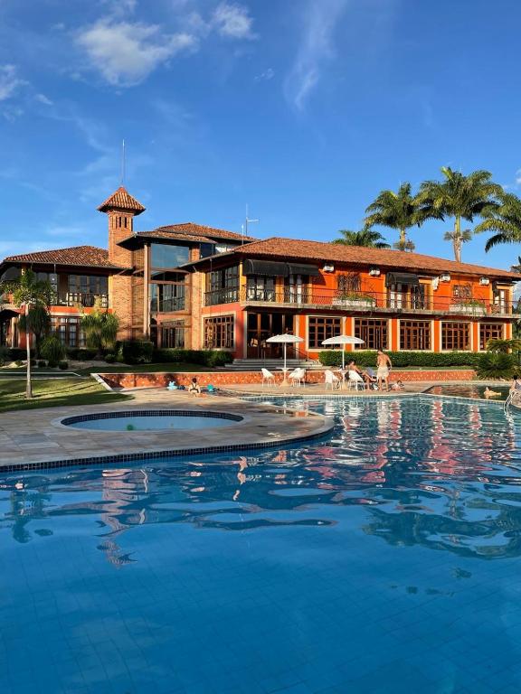 a large swimming pool in front of a building at Hotel Fazenda Lagoa Grande in Sete Lagoas