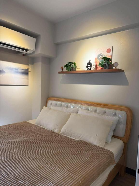 a bedroom with a bed and a shelf on the wall at Verdon Parc condominium in Davao City