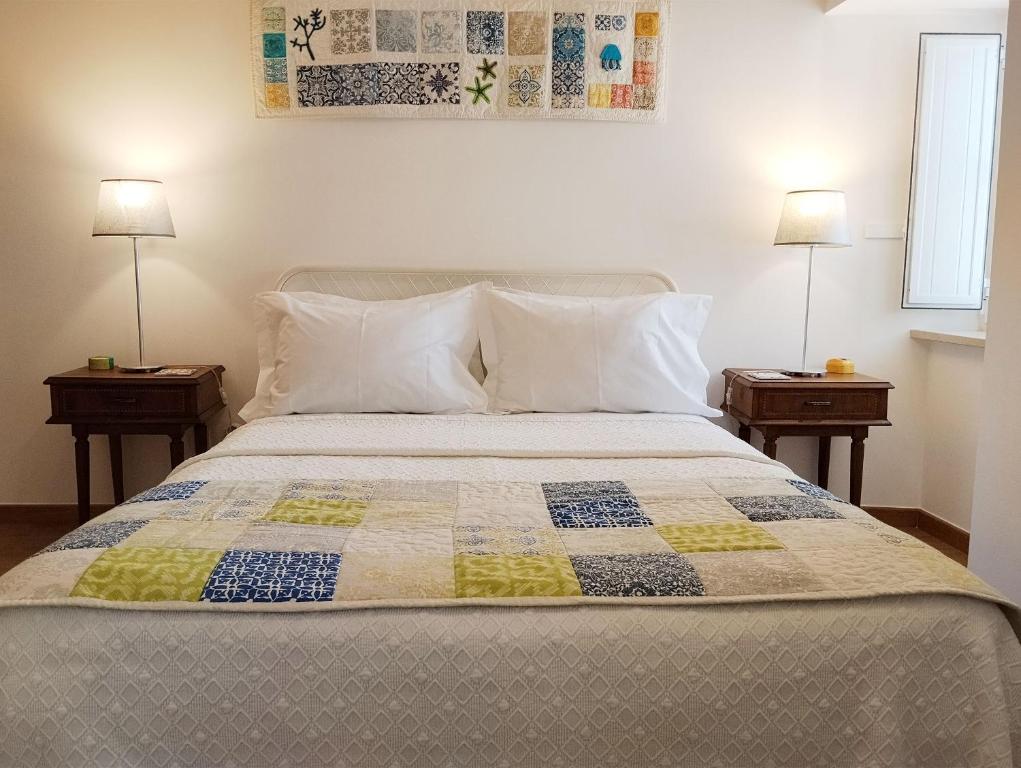 a bedroom with a bed with two nightstands and two lamps at Yellow House in Tavira