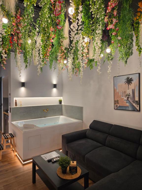 a living room with a couch and a bath tub at Botanica Noir Jacuzzi Valaoritou in Thessaloniki