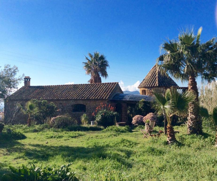 a house with palm trees in front of it at Holiday House La Teja in Facinas