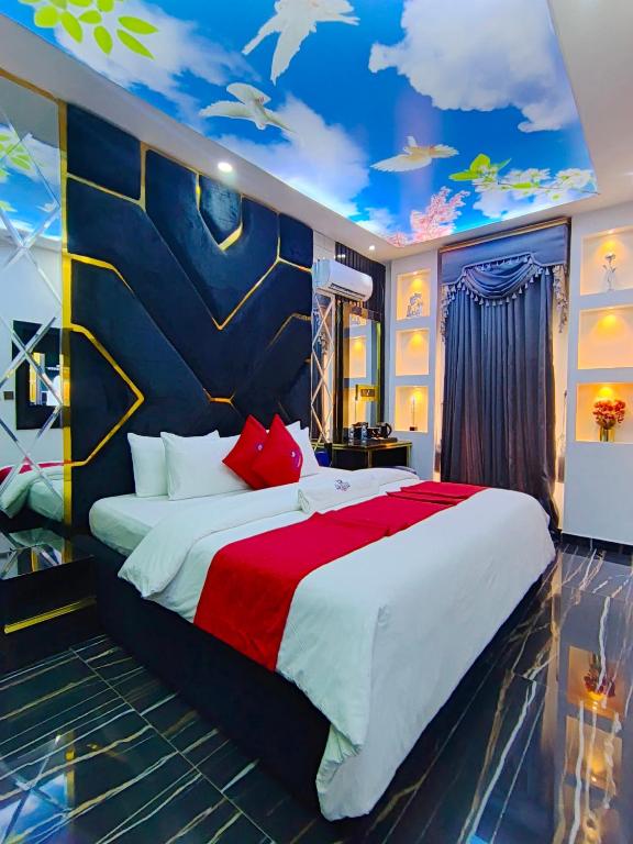 a bedroom with a large bed with a painting on the ceiling at Fairtex Luxury Hotel in Lekki