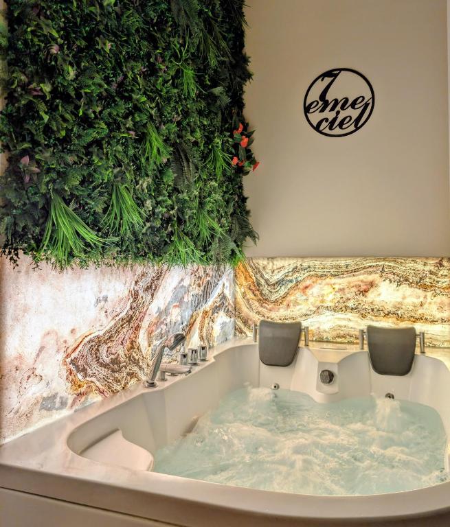 a bath tub with plants on the wall at Suite avec jacuzzi privatif in Vergèze