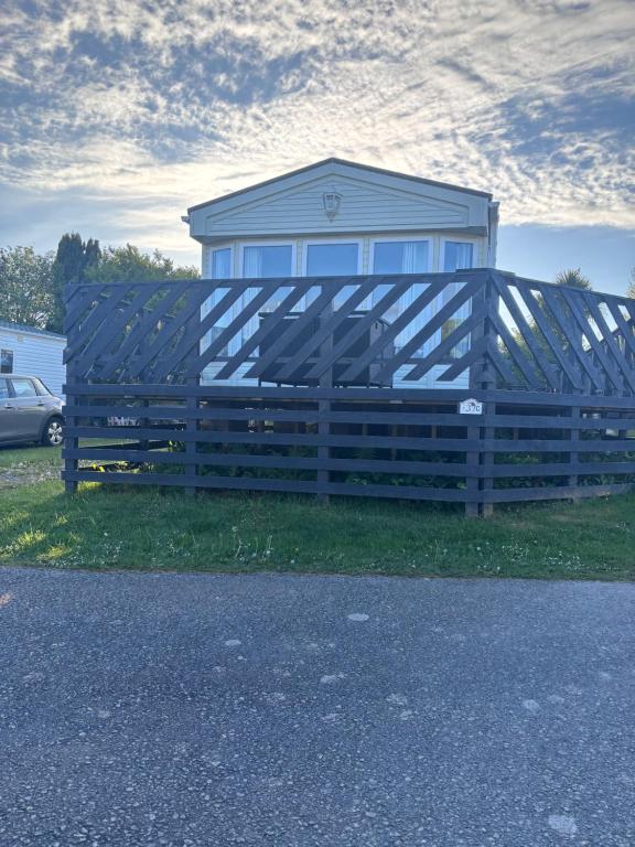 a wooden fence in front of a house at ty newydd leisure park in Brynteg