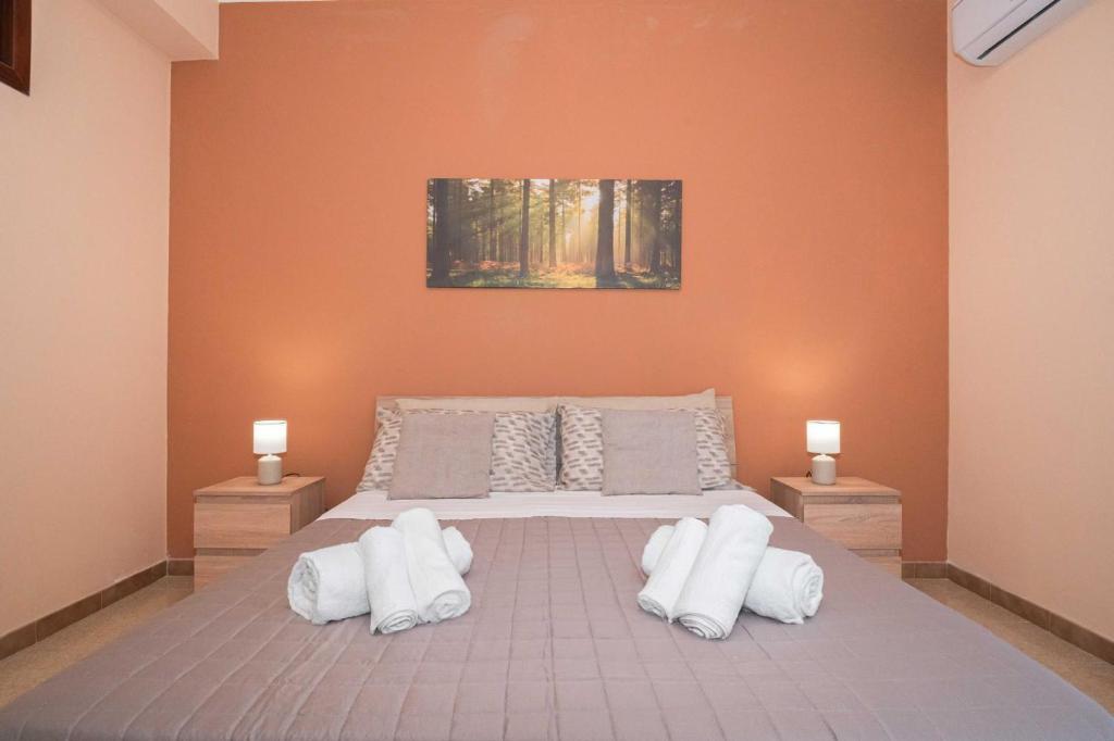 a bedroom with a large bed with white pillows at Kleos Apartment in Schisò