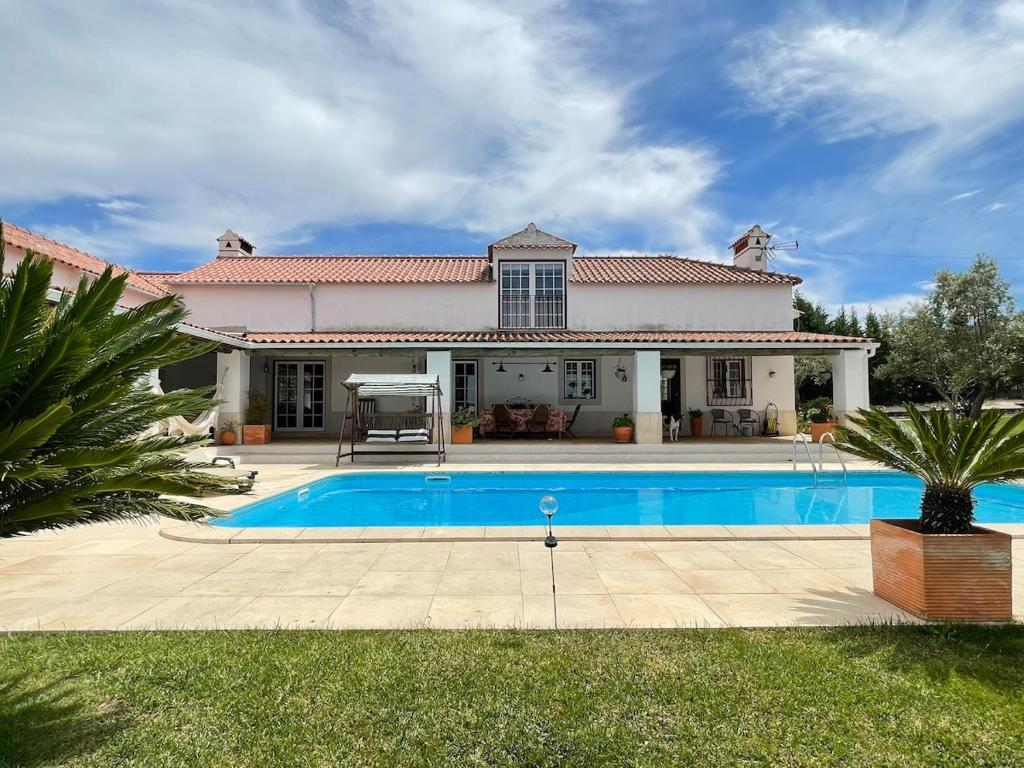 a house with a swimming pool in front of it at Casa dos Cedros in Bicas