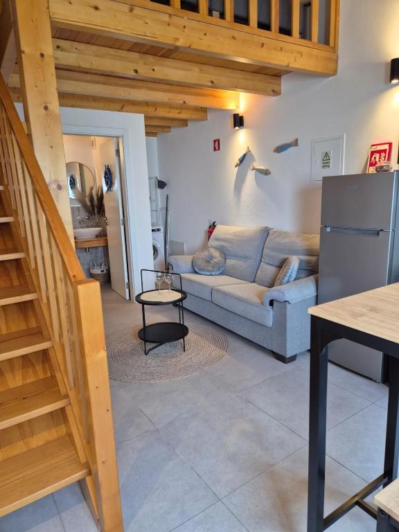 a living room with a couch and a staircase at Casa do Barco in Odiáxere