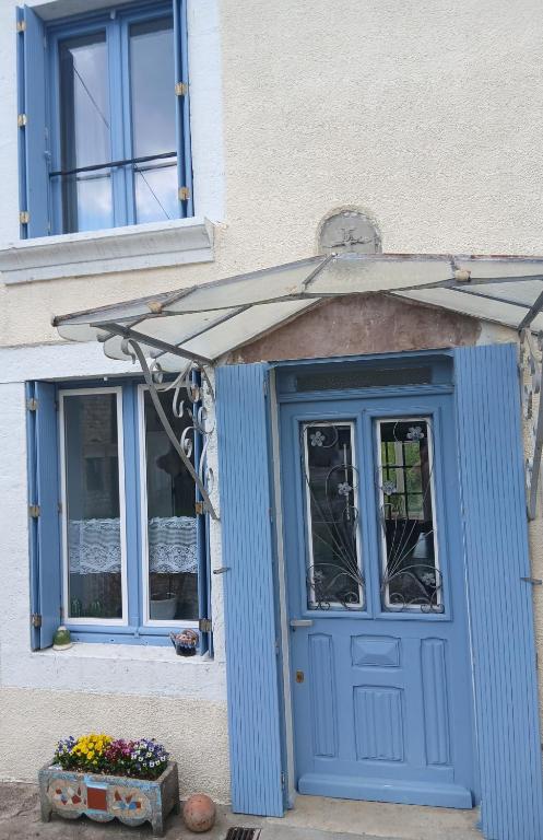 a blue door of a building with a window at gite du canal in Ormoy