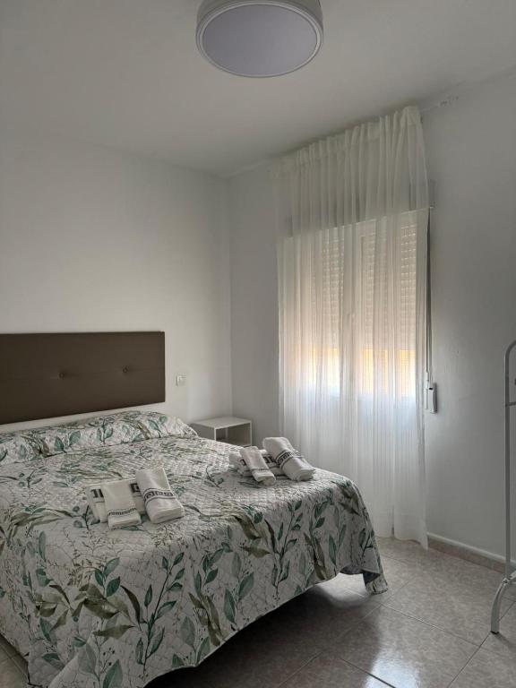 a bedroom with a bed with a blanket and a window at Berta Home in Mota del Cuervo