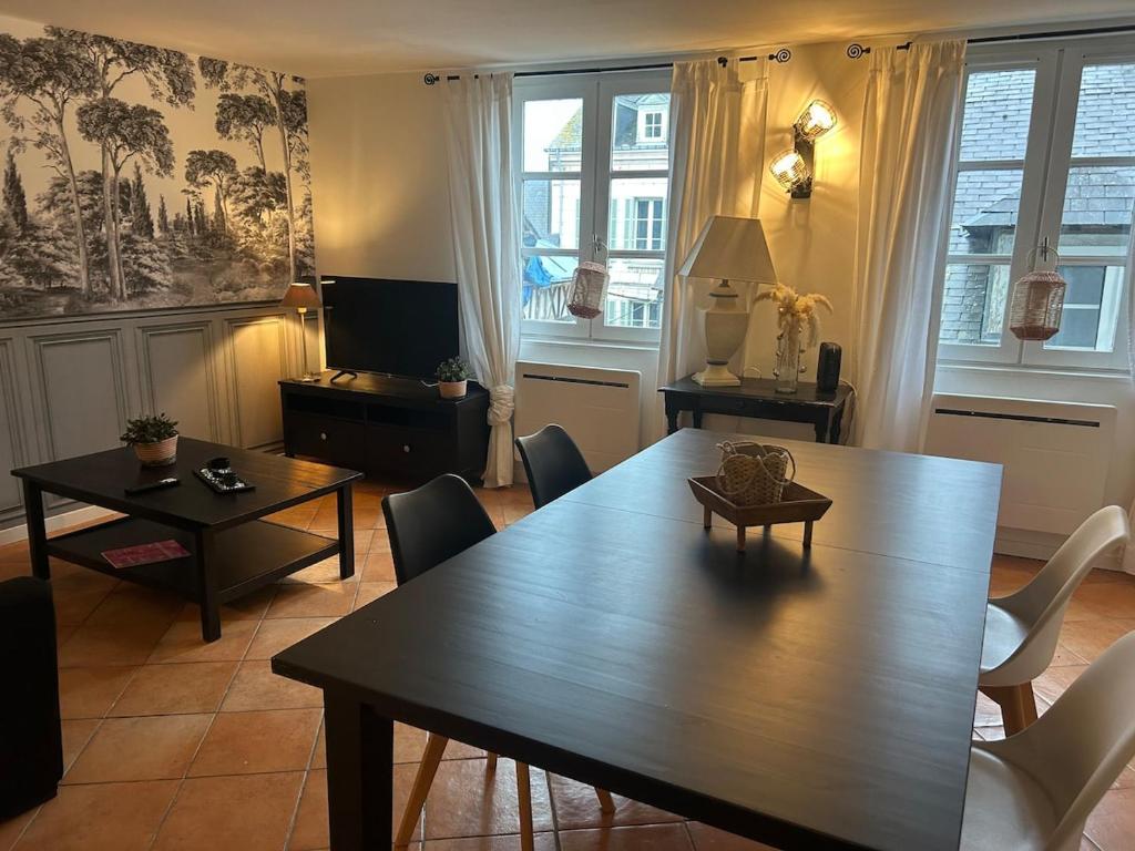 a living room with a wooden table and chairs at Duplex in Honfleur