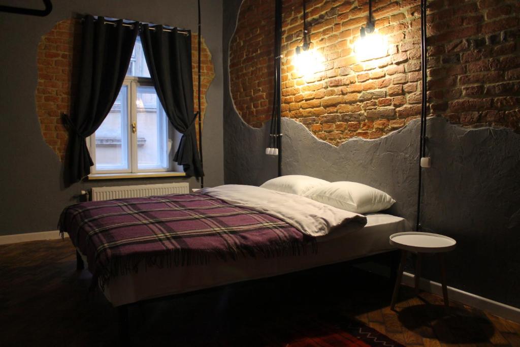 um quarto com uma cama e uma parede de tijolos em Lviv Loft Apartments em Lviv