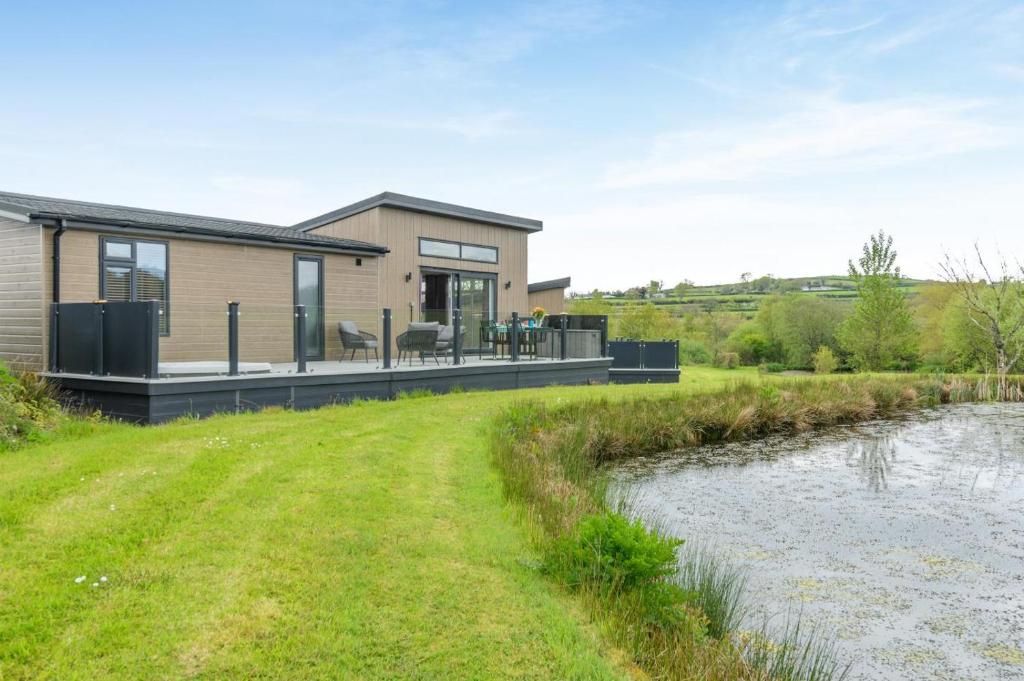 a house with a large deck next to a river at 2 Bed in Canaston Bridge oc-d34702 in Robeston Wathen