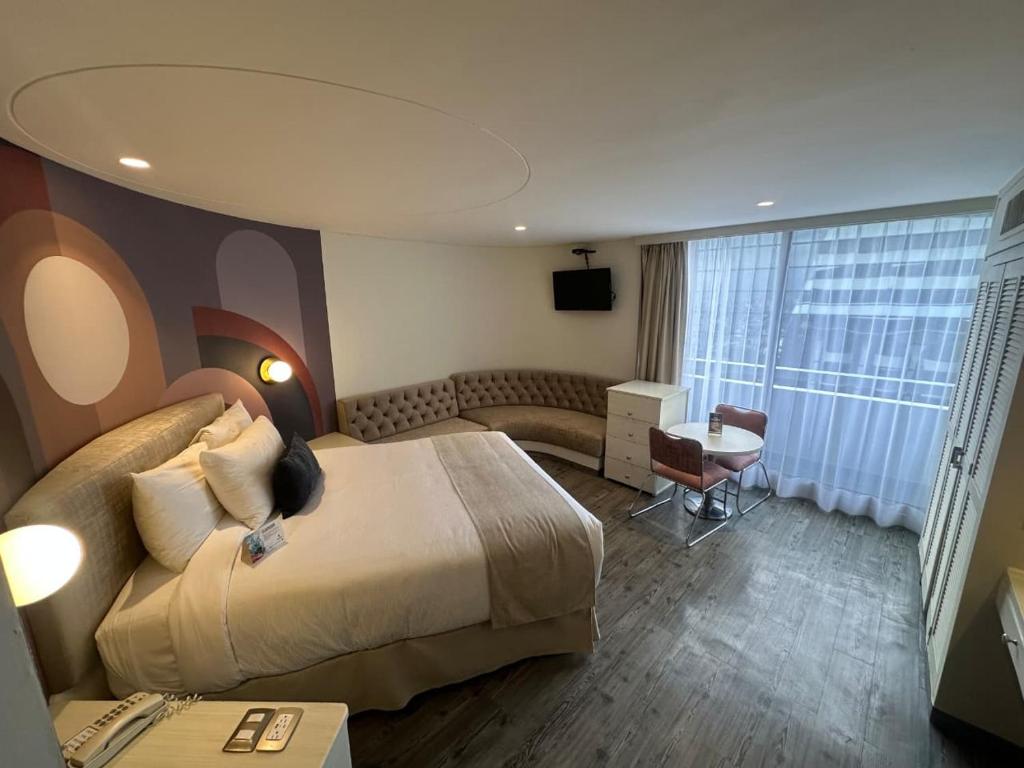 a hotel room with a large bed and a couch at Hotel Century Reforma in Mexico City