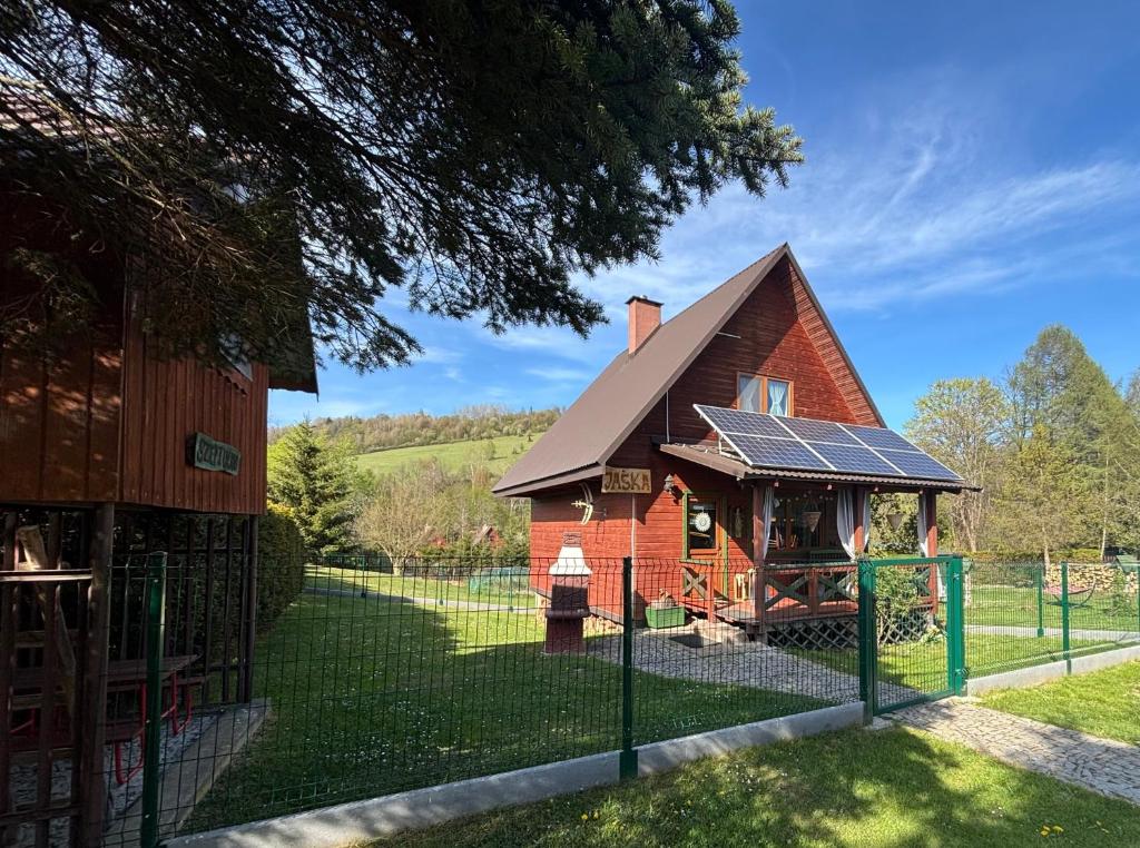 a small red house with solar panels on it at Domek Jaśka in Baligród