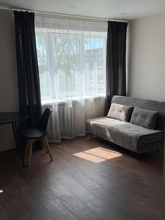 ein Wohnzimmer mit Sofa und Fenster in der Unterkunft 5A Group in Līvāni