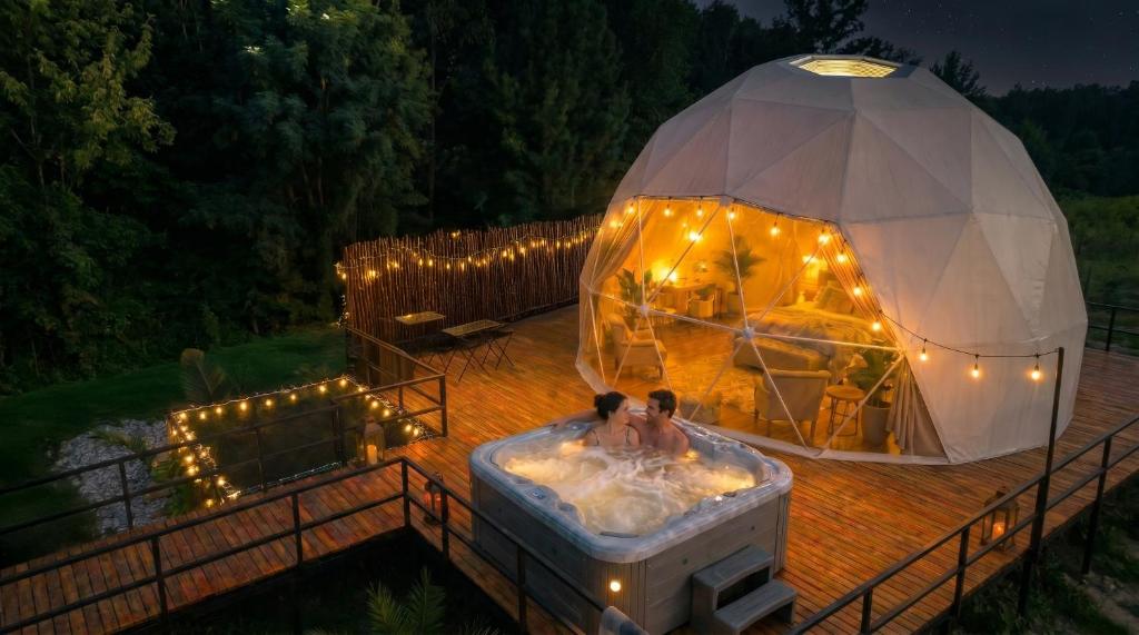 two people in a tub in a igloo with lights at Vilodge in Charrúa