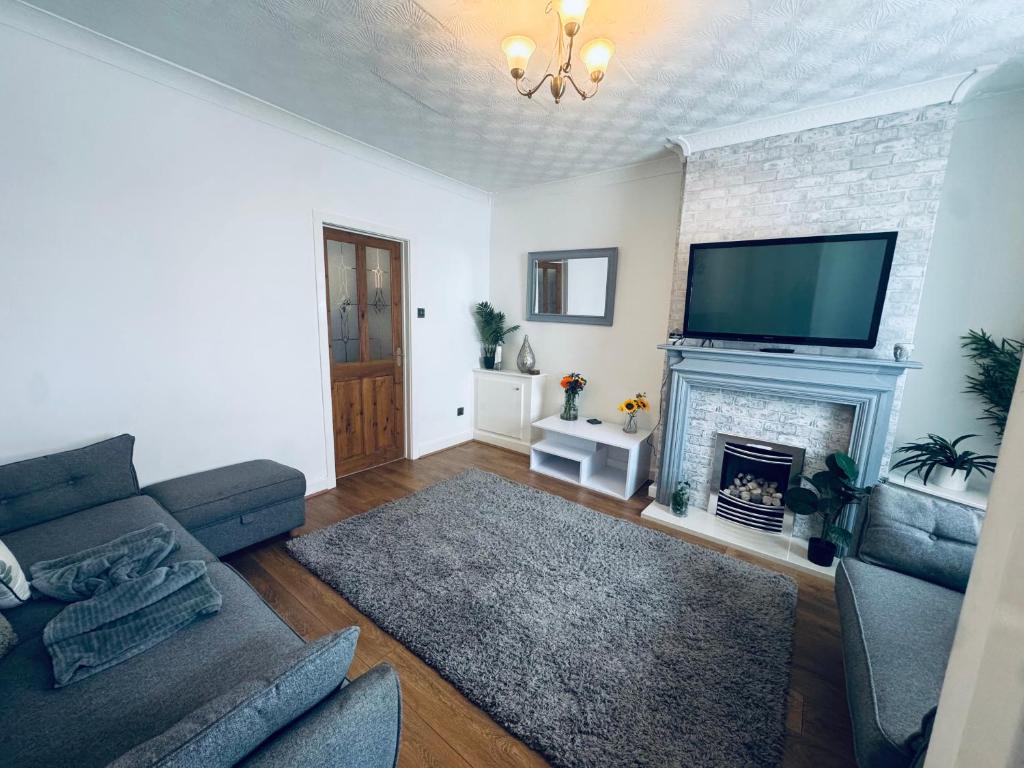 a living room with a couch and a fireplace at Lonsdale Terrace - 3 Bedrooms - Sleeps 6 in Workington