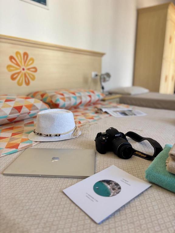a bed with a hat and a laptop on it at Agriturismo Vistamare in Orosei