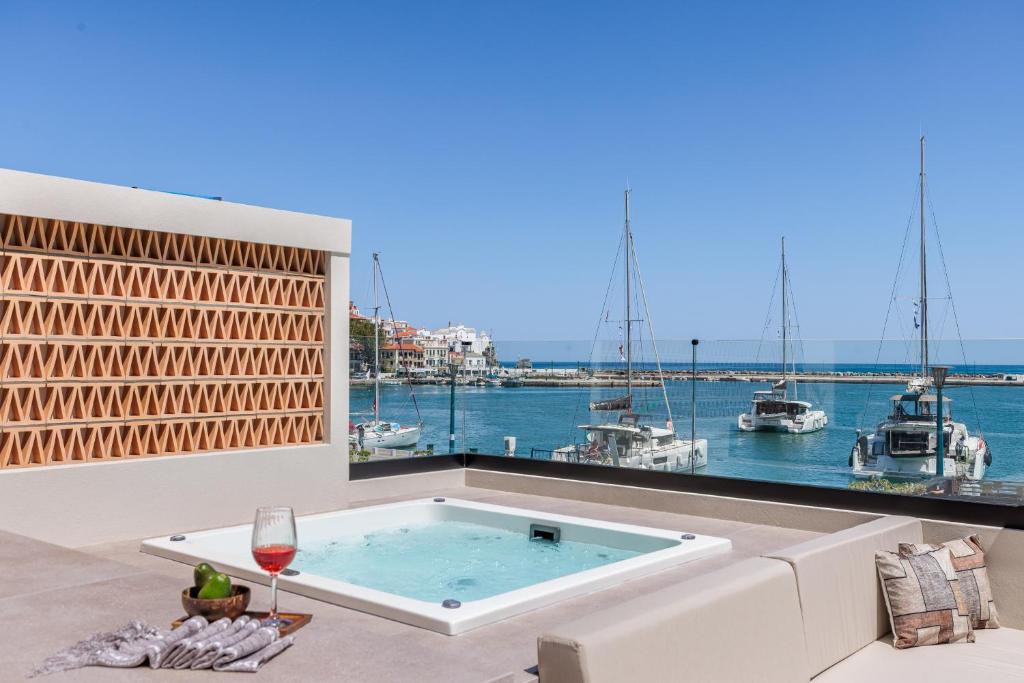 a hot tub on a patio with a view of the water at Cavo Mare Skopelos in Skopelos Town