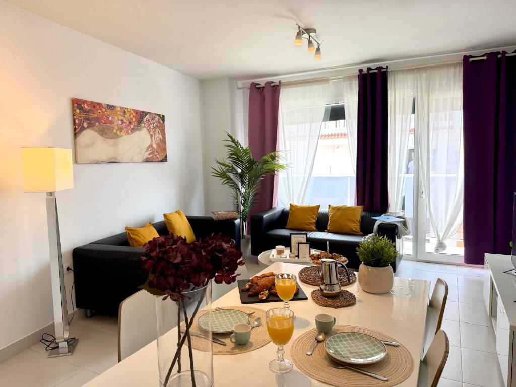 a living room with a table and a couch at Hortensia Suites Apartments, Los Cristianos, Tenerife in Los Cristianos