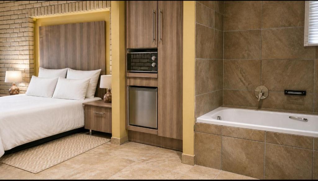 a bedroom with a bed and a bath tub at Gaecho Guesthouse in Thaba Nchu