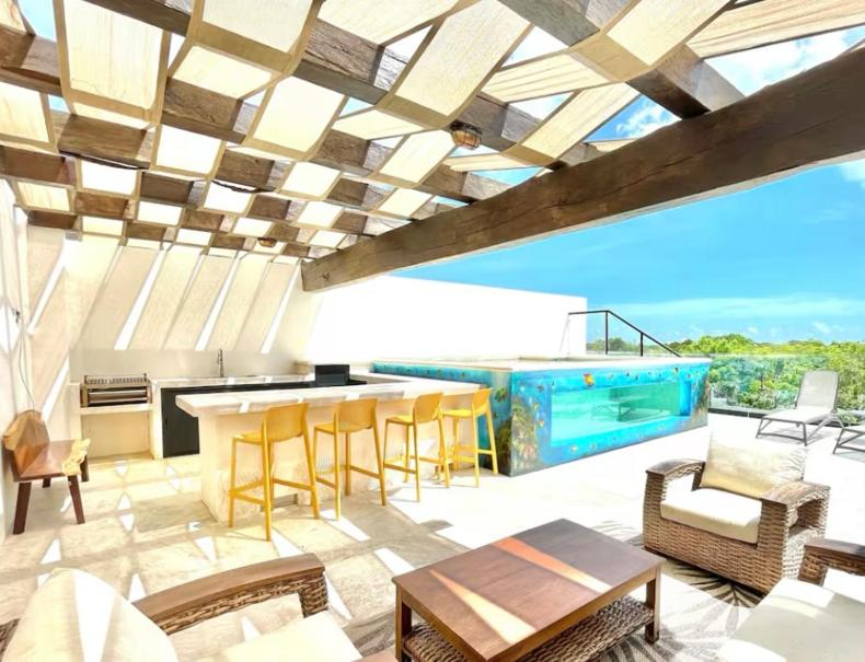 a patio with a table and chairs and a pool at Casa CooLas in Cozumel