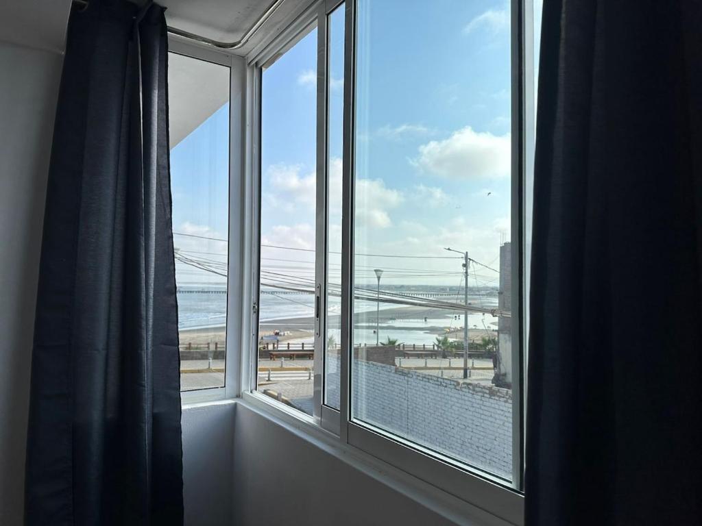 a room with a window with a view of a bridge at Mamá María Surf House in Puerto Chicama