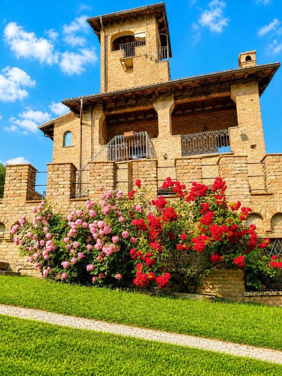 a brick building with flowers in front of it at Il Castelletto di Gomo - Relax nella natura con SPA privata outdoor in Godiasco