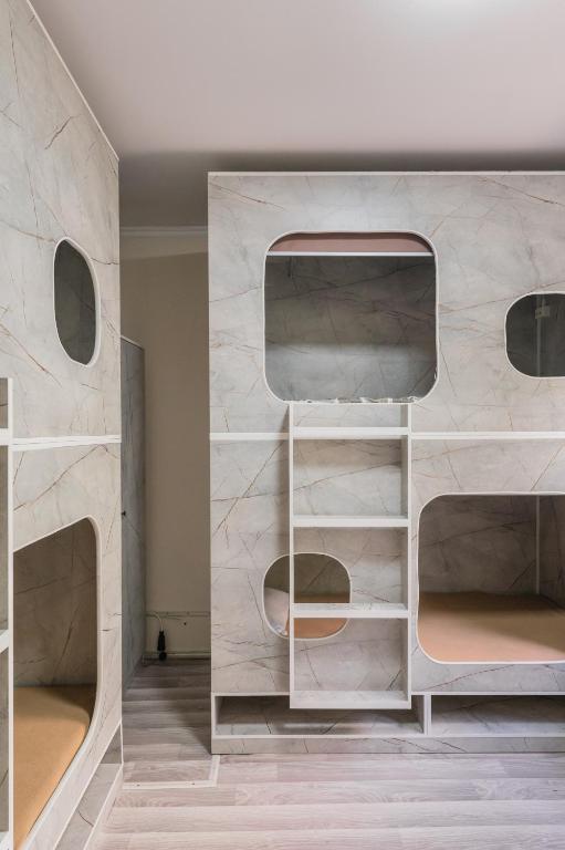 a room with three bunk beds in a wall at Arch Hostel in Almaty
