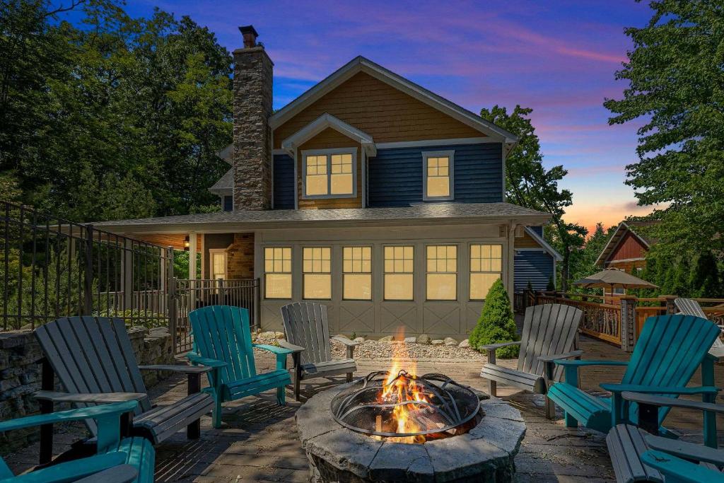 a backyard with chairs and a fire pit in front of a house at The Moose House by Juniper Holiday + Home in New Buffalo