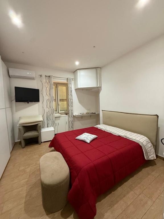 a bedroom with a red bed with a red blanket at Serena Guest House in Caserta