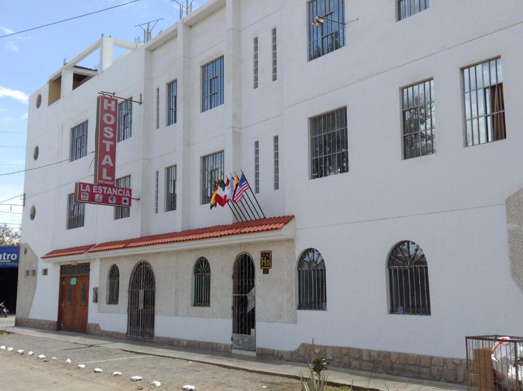 - un grand bâtiment blanc avec un panneau dans l'établissement Hostal La Estancia, à Ica
